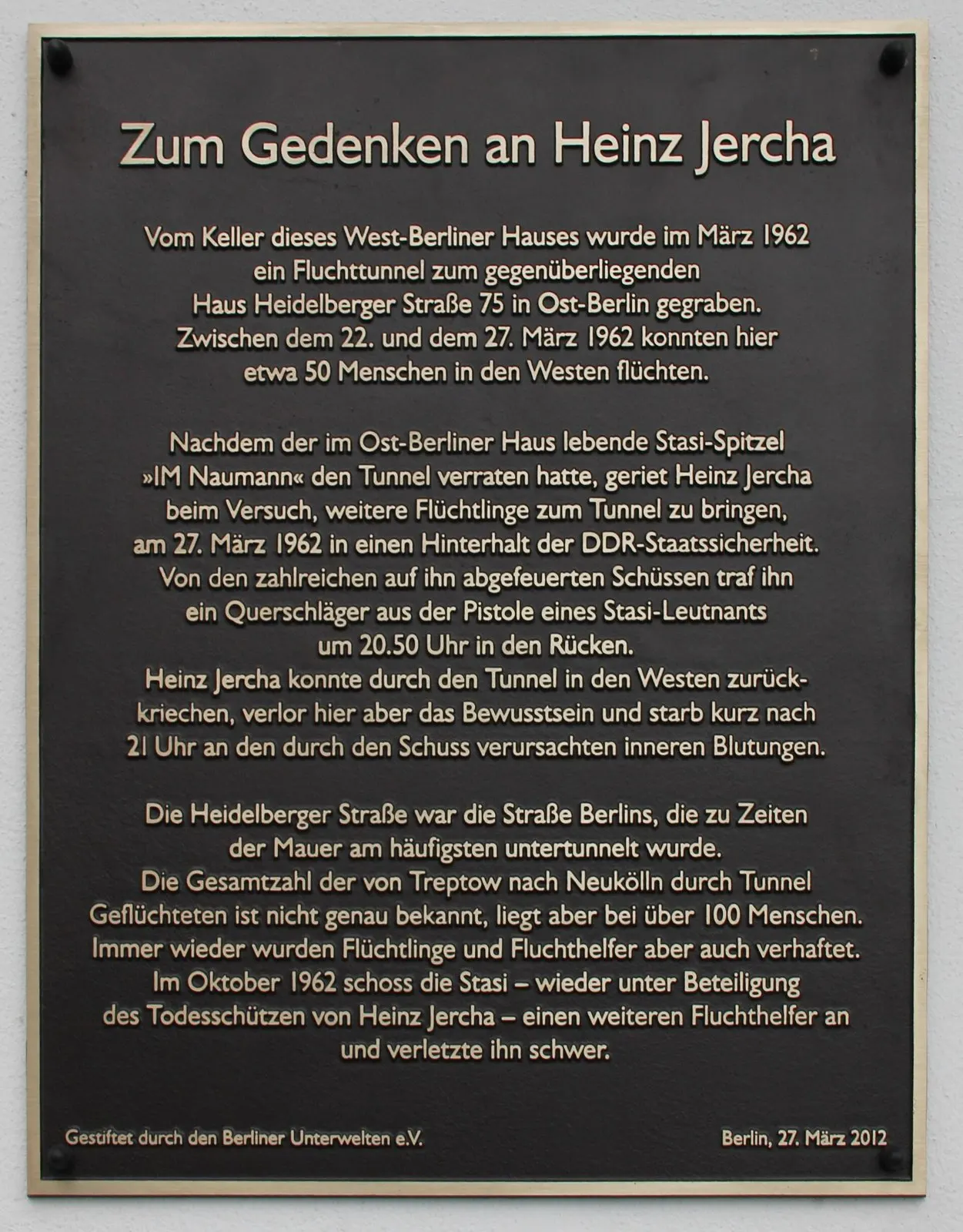 Dark bronze plaque headed "Zum Gedenken an Heinz Jercha" with text about an escape tunnel