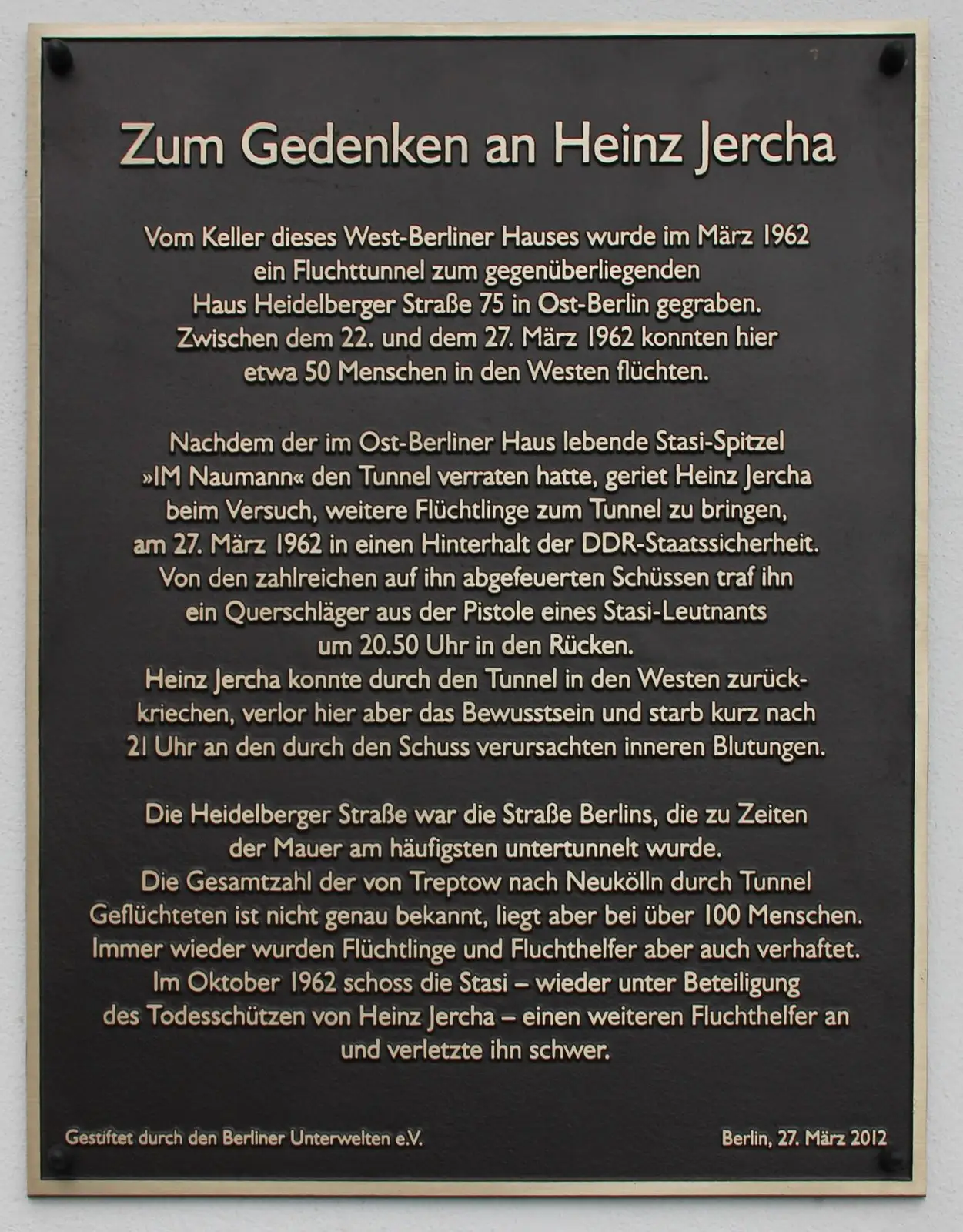 Dark bronze plaque headed "Zum Gedenken an Heinz Jercha" with text about an escape tunnel