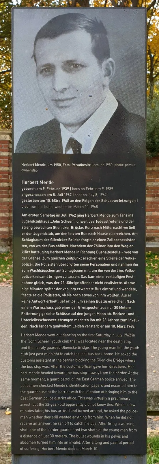 Panel with a large black-and-white photograph of a man in a white shirt and tie, above German and English text headed "Herbert Mende"