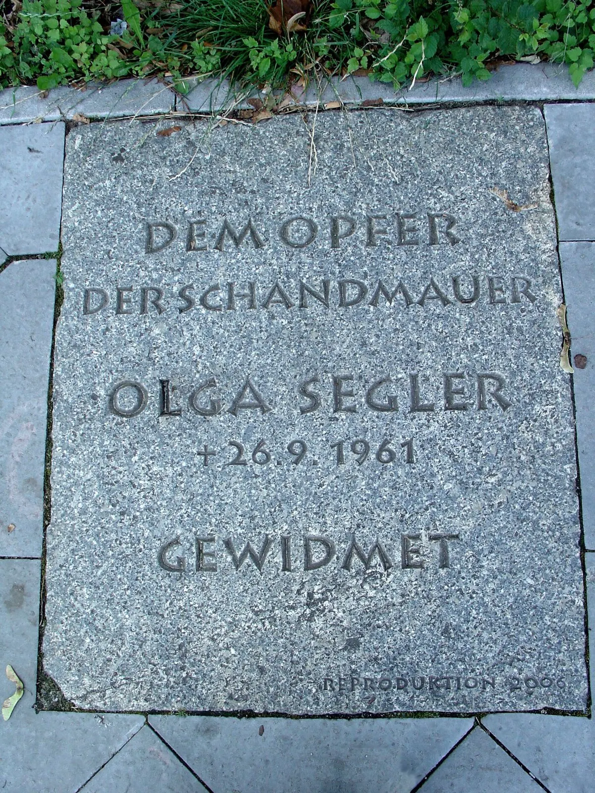Granite slab in the pavement engraved "Dem Opfer der Schandmauer Olga Segler † 26.9.1961 gewidmet"