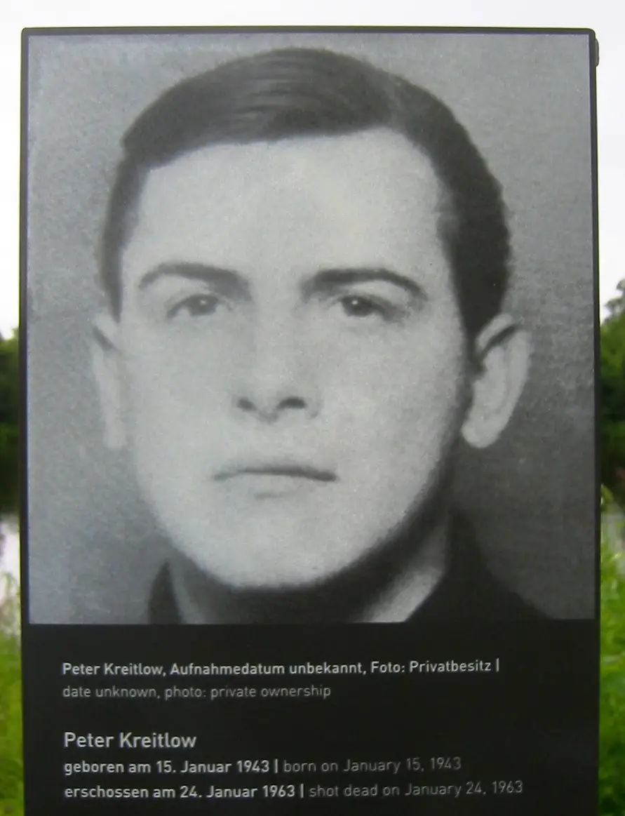 Black-and-white portrait photograph of a young man with dark hair, above the printed caption with his name and dates