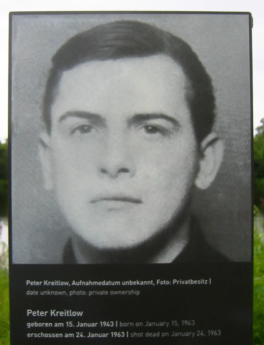 Black-and-white portrait photograph of a young man with dark hair, above the printed caption with his name and dates