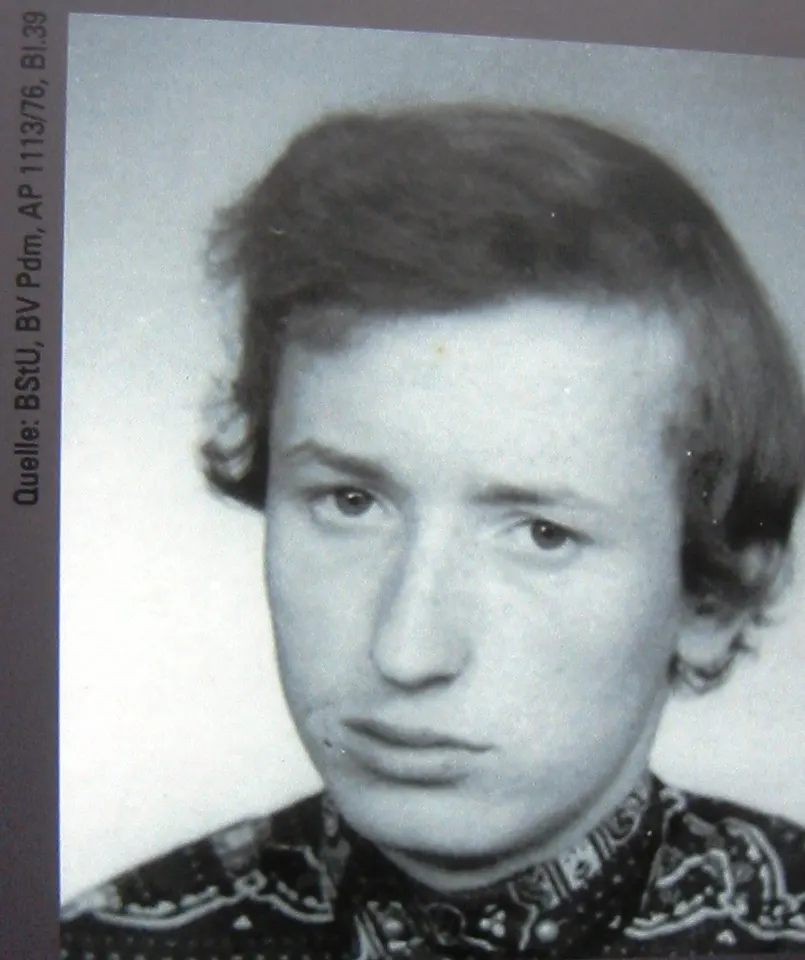 Black-and-white head-and-shoulders photograph of a young man with a side parting and a patterned shirt