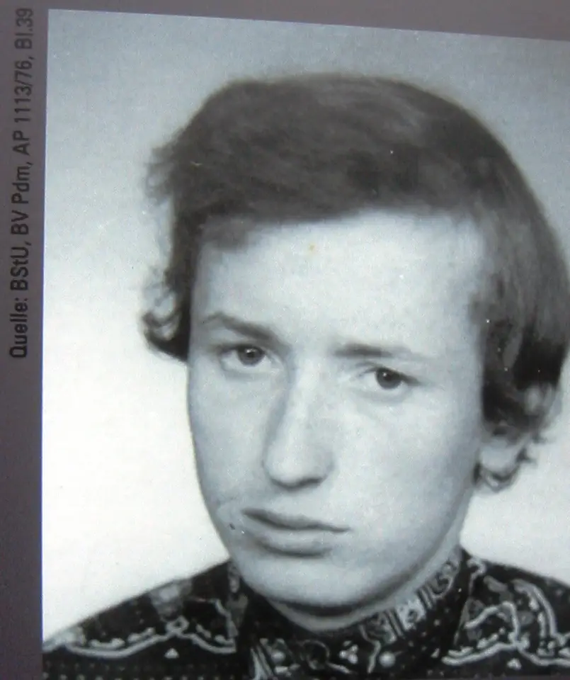 Black-and-white head-and-shoulders photograph of a young man with a side parting and a patterned shirt