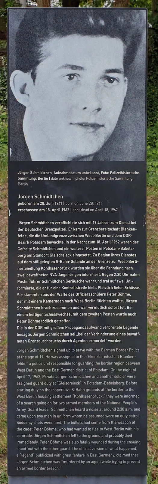 Grey stele with a black-and-white portrait of a young man at the top and German and English text below