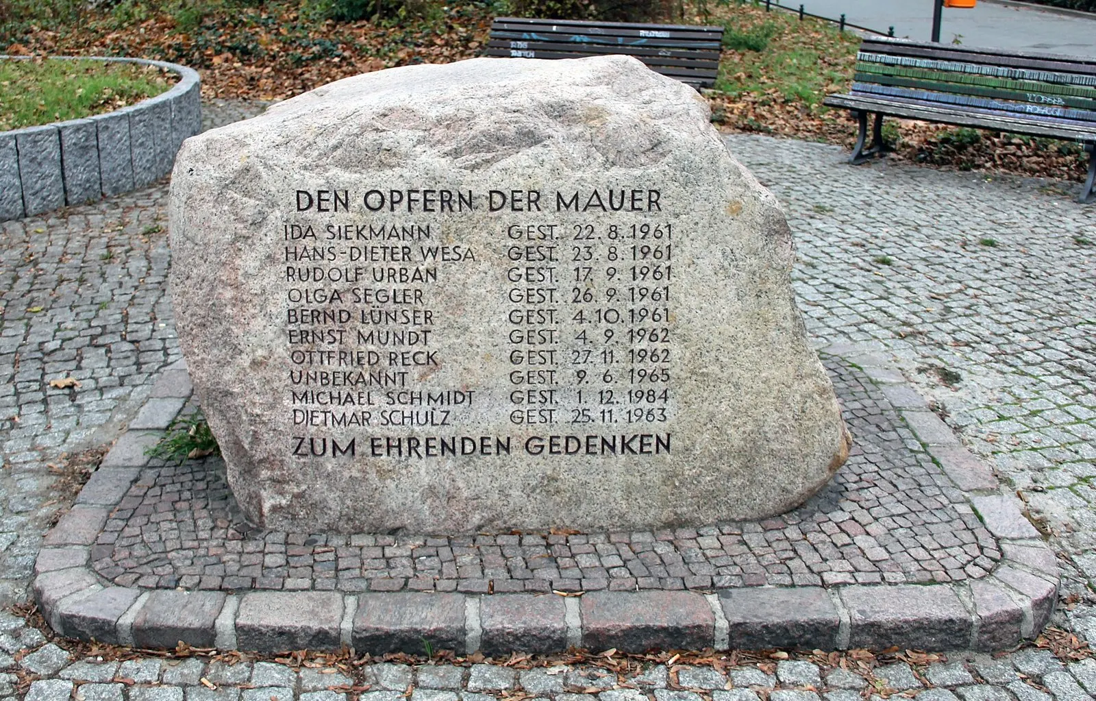 Large granite boulder on cobbles engraved with a list of names and dates under "Den Opfern der Mauer"