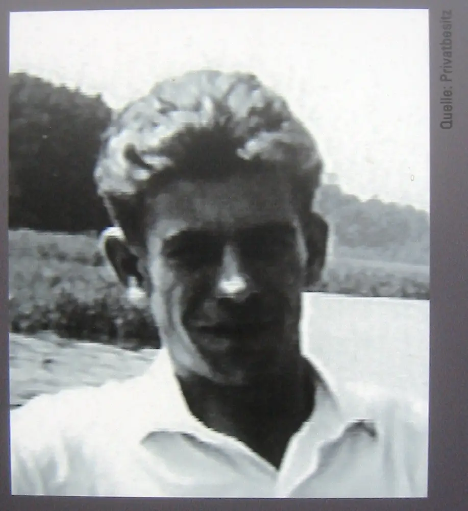 Black-and-white photograph of a young man with light wavy hair and an open white shirt, outdoors, with the credit "Quelle: Privatbesitz" at the edge
