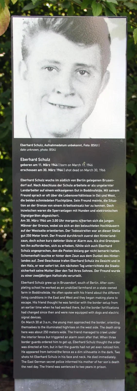Panel with a large black-and-white photograph of a smiling young man with light hair, above German and English text headed "Eberhard Schulz"
