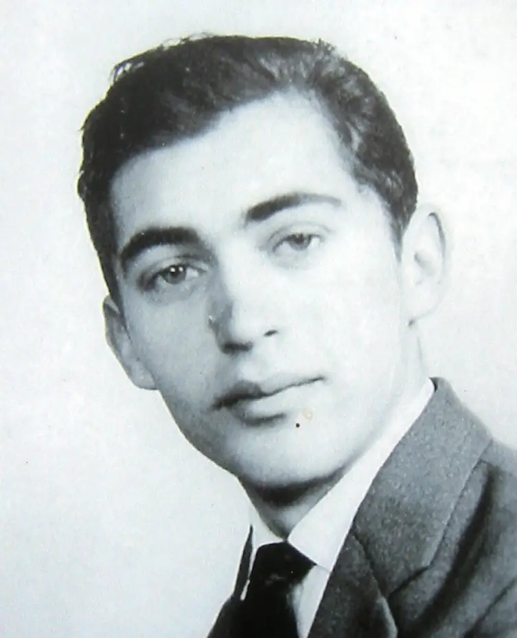 Black-and-white portrait of a young man with dark hair in a jacket, white shirt and dark tie