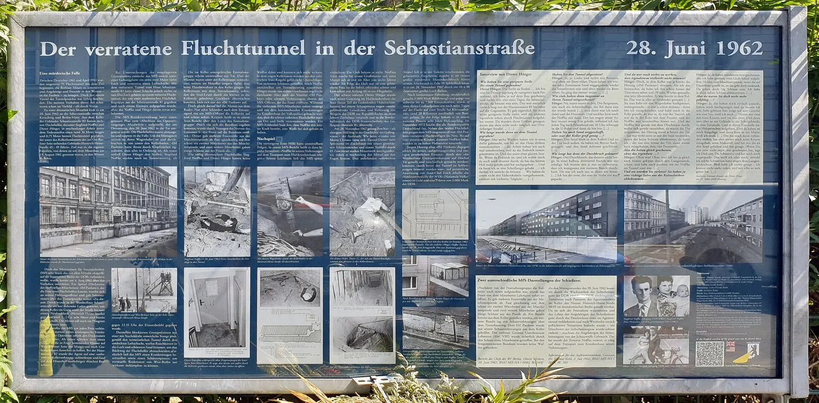 Large blue information board with text and black-and-white photographs
