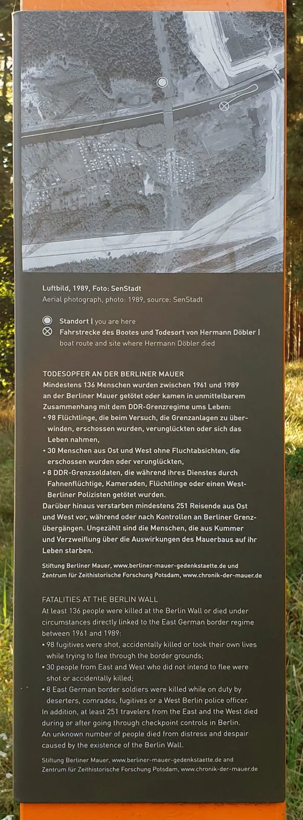 Information panel with an aerial photograph of a canal and bridge with marked points, above text