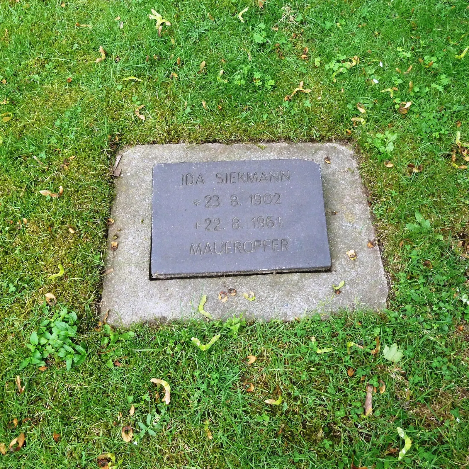 Small dark grave plate in grass inscribed "Ida Siekmann 23.8.1902 22.8.1961 Maueropfer"