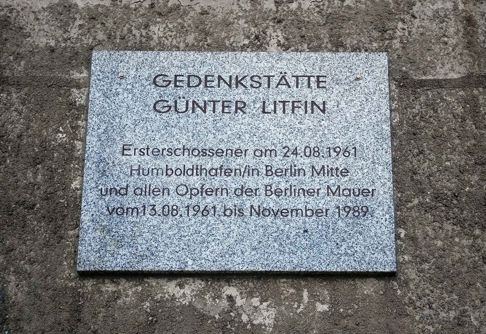 Granite plaque on a concrete wall reading "Gedenkstätte Günter Litfin" with the dates of the Wall